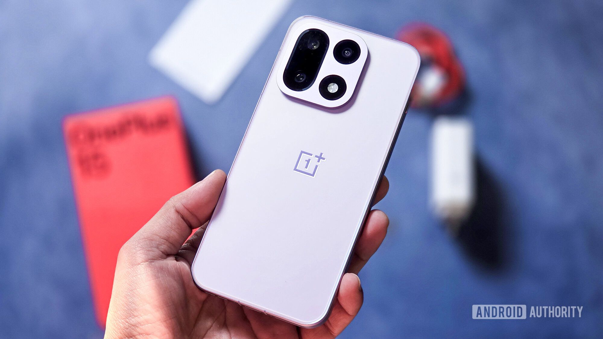 Вид сзади на фиолетовый корпус смартфона OnePlus 15, лежащего на ровной поверхности